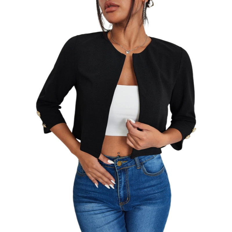 Frau trägt schwarze, elegante Jacke mit Dreiviertelärmeln, kombiniert mit weißem Top und blauer Jeans. Modetrend, Damenmode, stilvoller Look.