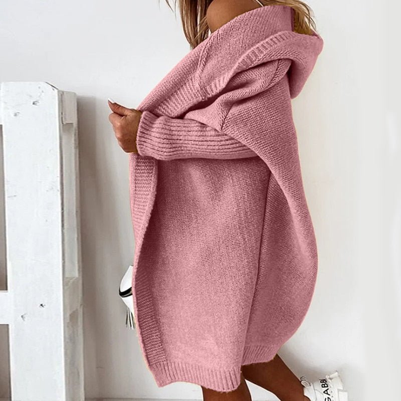Frau in rosa Strickjacke mit Kapuze, lässiger Stil, seitliche Ansicht. Perfekt für Herbstmode, gemütlich und stilvoll.