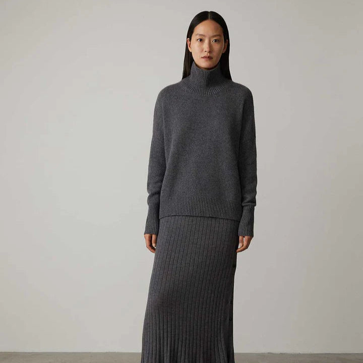 Frau in grauem Rollkragenpullover und langem Rock, minimalistisch, Mode, Herbst-Winter-Outfit, eleganter Look, Studioaufnahme.