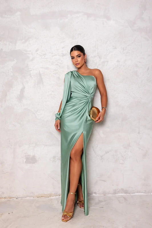 Elegantes Abendkleid in Mintgrün mit asymmetrischem Schnitt und hohem Beinschlitz, kombiniert mit goldener Clutch und Sandaletten.