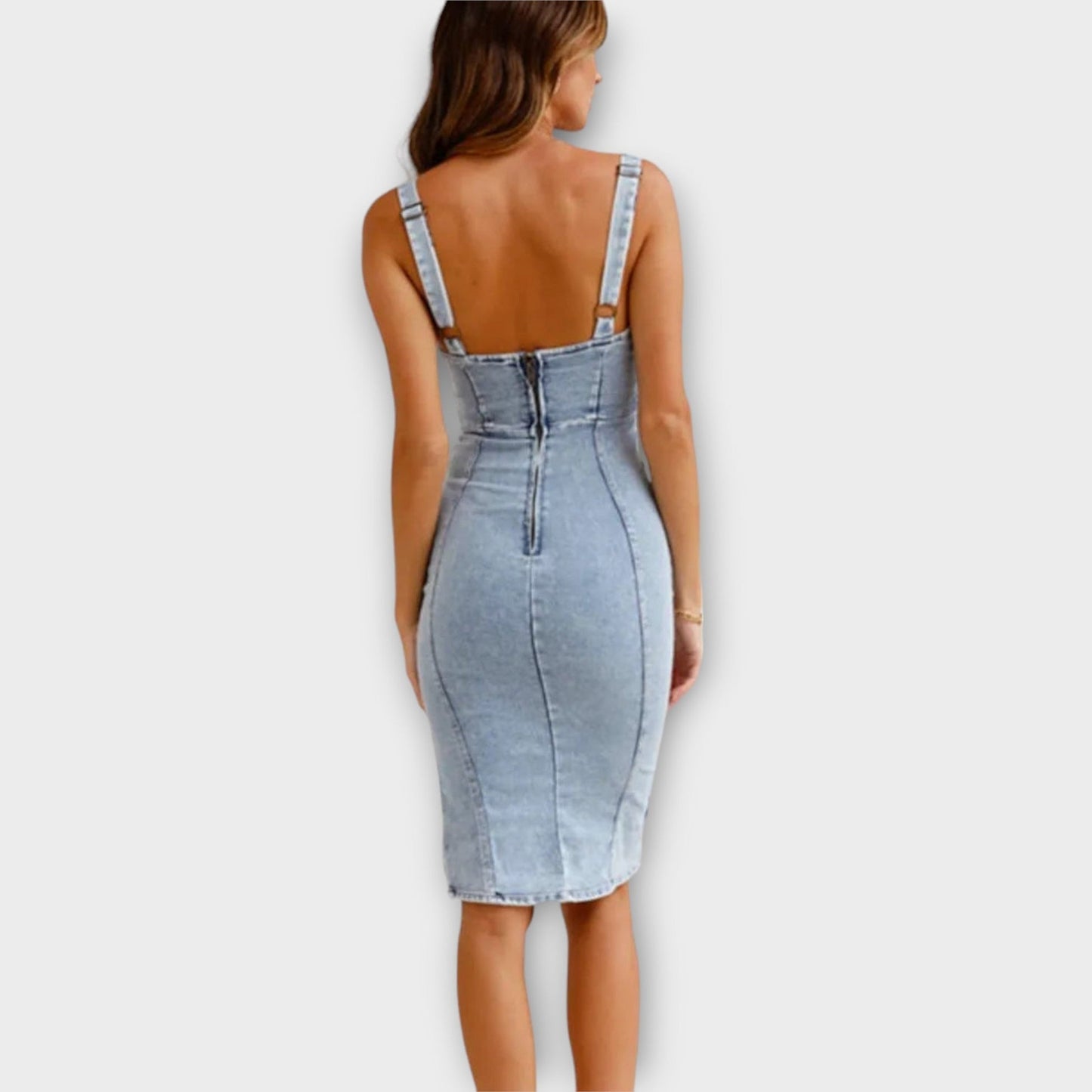 Frau in figurbetontem, ärmellosem Jeanskleid mit Reißverschluss hinten, modisch und elegant, ideal für Sommermode und Freizeitkleidung.