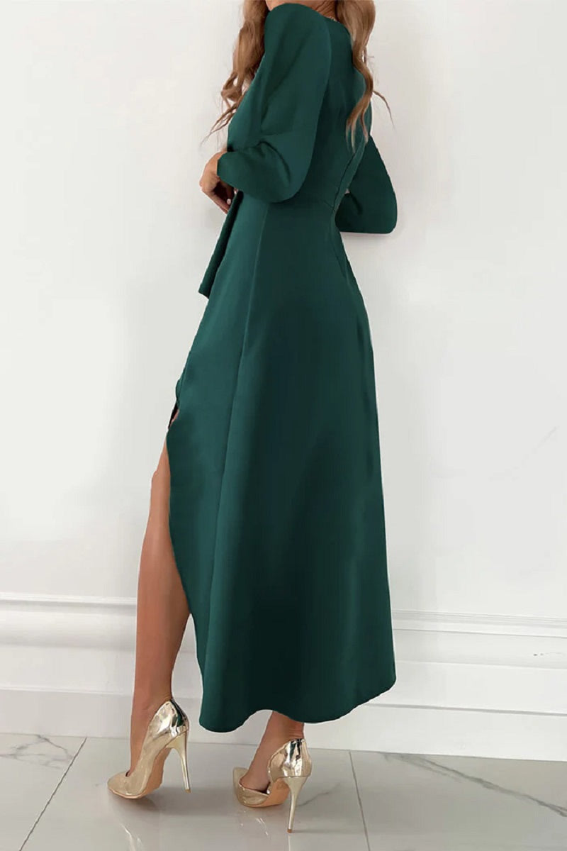 Grünes langes Kleid mit Schlitz, elegantes Design, getragen von Frau mit goldenen High Heels, modisches Abendoutfit, stilvolle Damenmode.