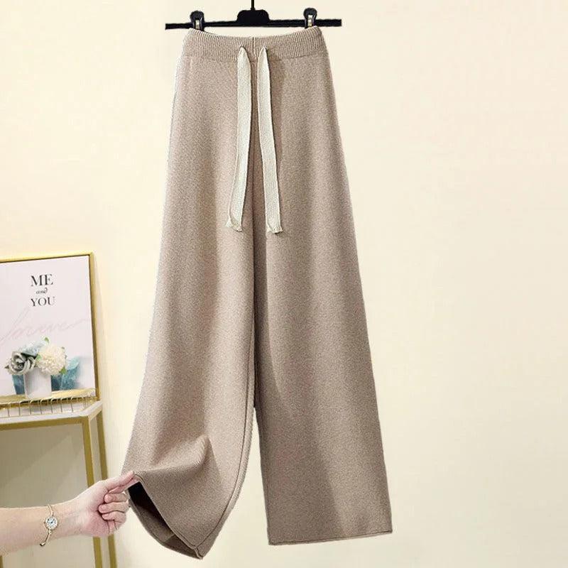Beige Damen-Strickhose mit weitem Bein und Kordelzug, hängend an einem Kleiderbügel. Modische, bequeme Lounge-Hose für Freizeit und Alltag.