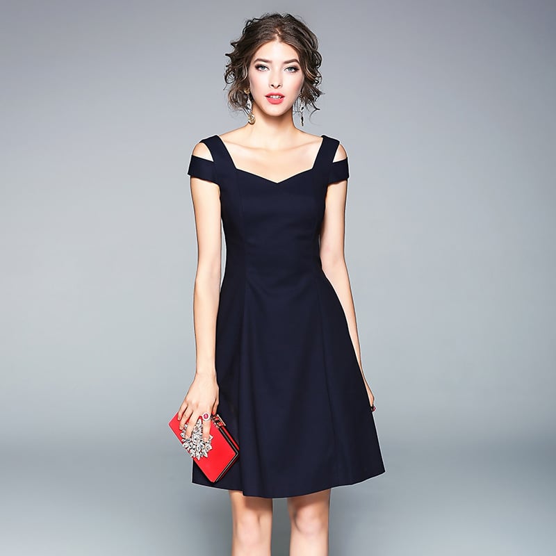 Frau in elegantem, schwarzem Cocktailkleid mit roten Clutch. Abendmode, schulterfrei, stilvoll, modisch. Perfekt für besondere Anlässe.
