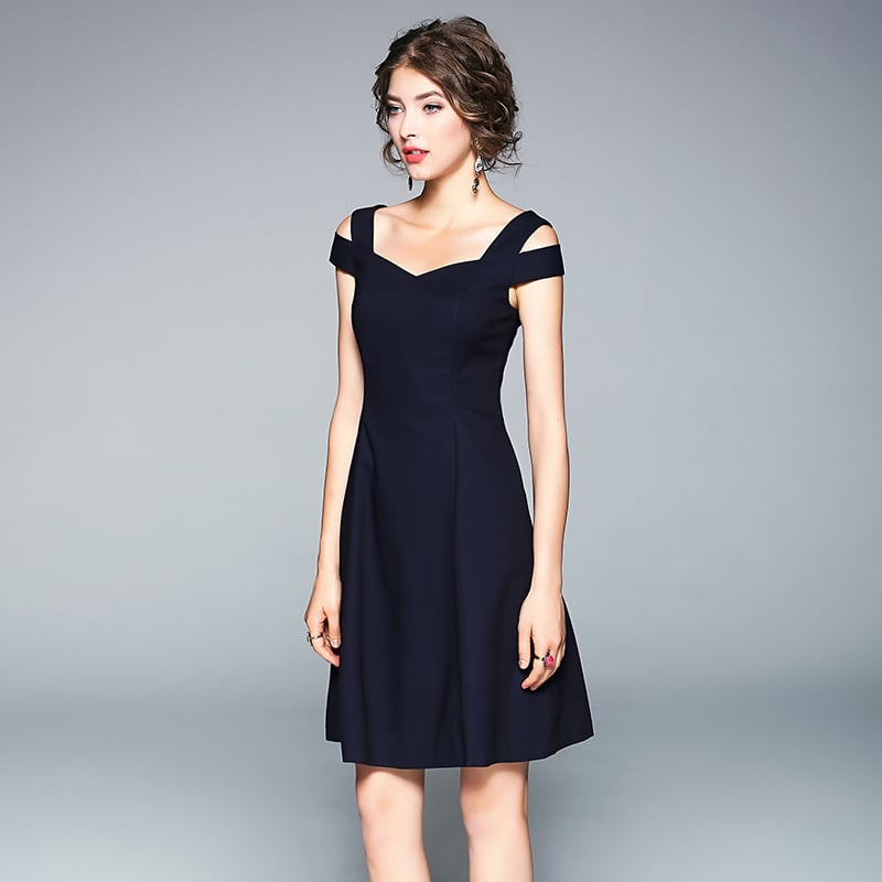 Frau in elegantem, schulterfreiem, dunkelblauem Cocktailkleid vor grauem Hintergrund. Abendmode, Damenkleidung, stilvolles Design.