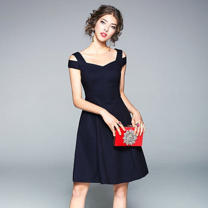 Eine Frau in einem eleganten, schwarzen Cocktailkleid mit Trägern hält eine rote Clutch. Perfekt für Abendmode und stilvolle Anlässe.