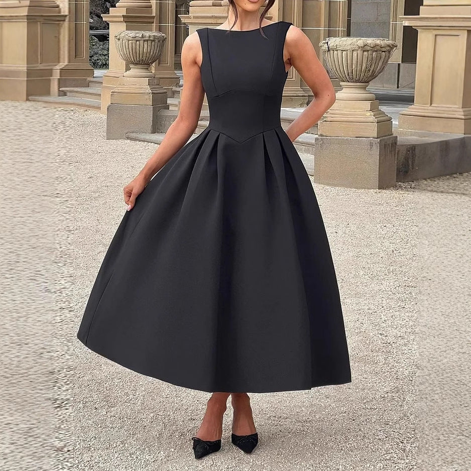 Elegantes schwarzes Abendkleid, ärmellos, knielang, mit ausgestelltem Rock, getragen von einer Frau vor klassischer Architektur. Perfekt für formelle Anlässe.