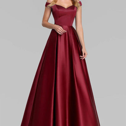Frau in elegantem, schulterfreiem, bordeauxrotem Abendkleid aus Satin. Perfekt für formelle Anlässe, Ballkleider, Abendmode.