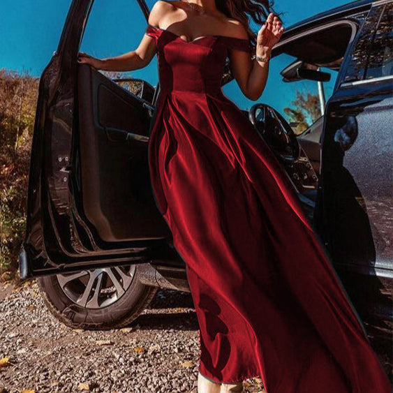 Frau in elegantem, schulterfreiem rotem Abendkleid steigt aus Auto. Luxuriöse Mode, Abendgarderobe, stilvolle Kleidung, glamouröser Auftritt.