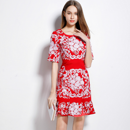 Frau in rotem Kleid mit weißem Blumenmuster, hält eine Clutch. Elegantes Design, modisches Outfit, stilvolle Damenmode.