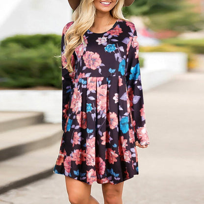 Frau in geblümtem Kleid mit langen Ärmeln und Hut, lächelnd im Freien. Modetrend, Damenmode, florales Design, Freizeitkleidung.