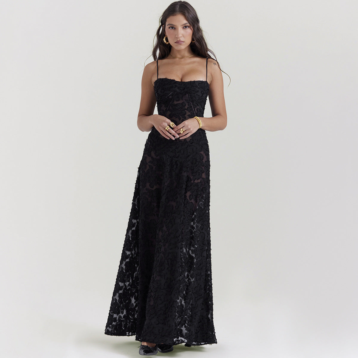 Frau in elegantem, schwarzem Spitzenkleid, bodenlang, mit Spaghettiträgern. Perfekt für Abendmode, Gala oder formelle Anlässe.