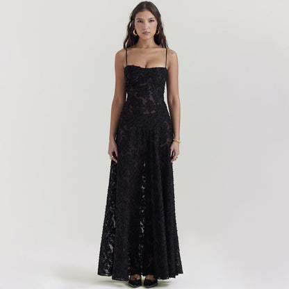 Frau in elegantem, schwarzem Abendkleid mit Spitzenmuster, Spaghettiträgern und bodenlangem Schnitt. Perfekt für formelle Anlässe und Abendveranstaltungen.