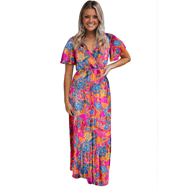 Frau in langem, buntem Blumenkleid mit V-Ausschnitt und kurzen Ärmeln, lächelnd. Sommermode, Damenkleid, florales Design.