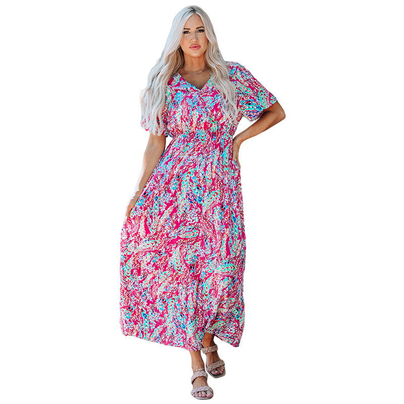 Frau in langem, buntem Sommerkleid mit abstraktem Muster, steht aufrecht. Mode, Damenbekleidung, farbenfrohes Kleid, Sommeroutfit.