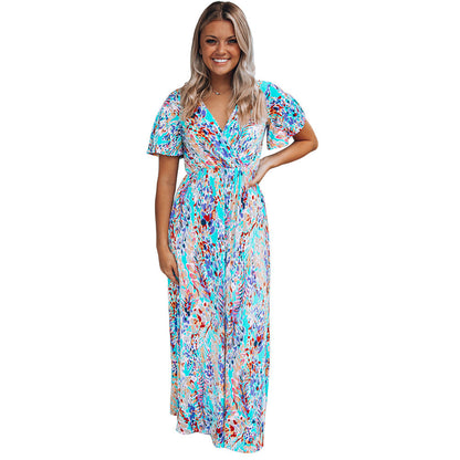 Frau in buntem Maxikleid mit floralem Muster, lächelt. Sommermode, Damenkleid, Freizeitkleidung, farbenfrohes Design, eleganter Look.