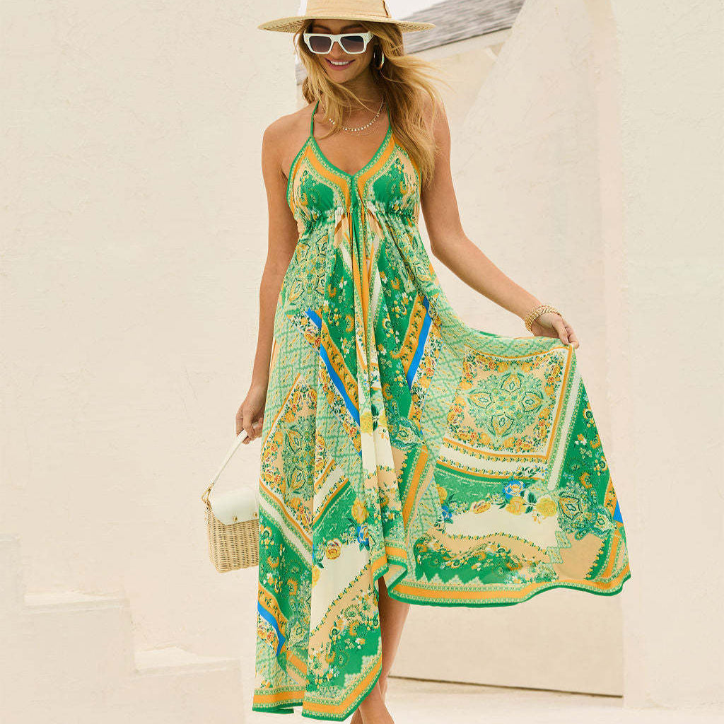 Blonde Frau in grünem Sommerkleid mit Paisley-Muster, Strohhut und Sonnenbrille, lächelnd vor hellem Hintergrund. Sommermode, Damenkleid, Strandlook.