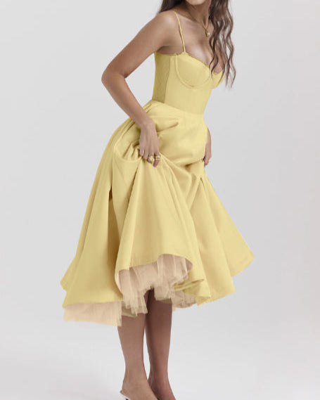 Frau in gelbem Cocktailkleid mit schwingendem Rock und Spaghettiträgern, elegante Mode, Abendkleid, stilvoll, feminin, zeitloses Design.