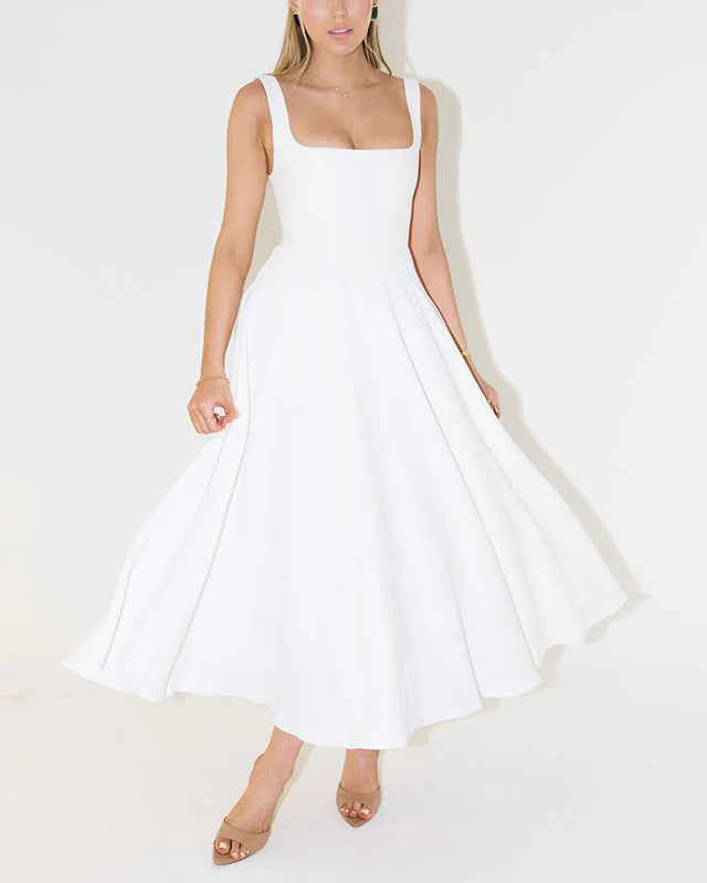 Weiße, ärmellose Damenkleid mit weitem Rock, elegantes Design, knielang, getragen von Frau mit beigen Sandalen, minimalistischer Hintergrund.