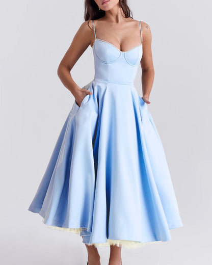 Frau in hellblauem, ärmellosem Kleid mit weitem Rock und Spaghettiträgern, elegantes Abendkleid, Modefotografie, stilvolle Damenbekleidung.