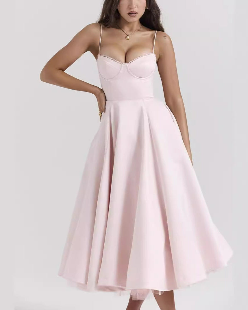 Frau in elegantem, rosa Abendkleid mit Spaghettiträgern und ausgestelltem Rock, ideal für formelle Anlässe oder Hochzeiten.