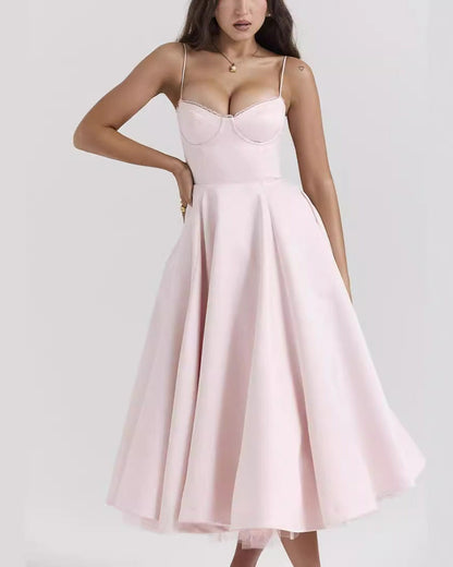 Frau in elegantem, rosa Abendkleid mit Spaghettiträgern und ausgestelltem Rock, ideal für formelle Anlässe oder Hochzeiten.