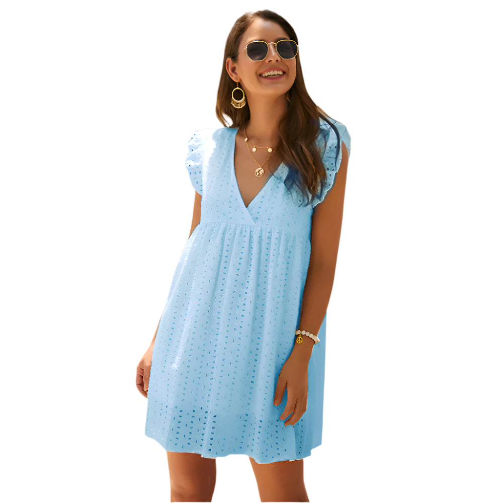 Frau in hellblauem Sommerkleid mit V-Ausschnitt und Rüschenärmeln, trägt Sonnenbrille und goldene Accessoires, lächelnd vor weißem Hintergrund.