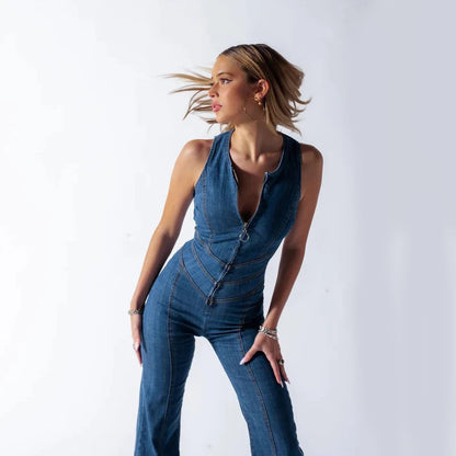 Frau in modischem, ärmellosem Jeans-Jumpsuit mit Reißverschluss, posiert dynamisch vor weißem Hintergrund. Trendige Damenmode, Denim-Look.
