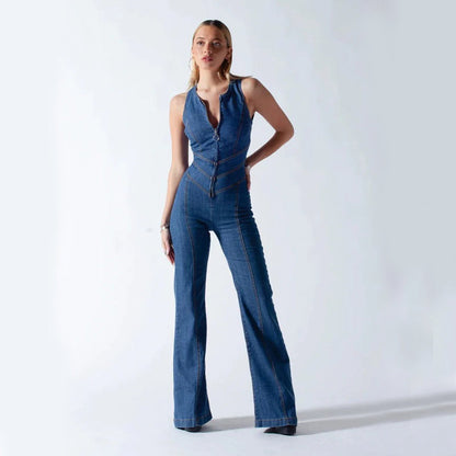 Frau in modischem, figurbetontem Jeans-Jumpsuit mit weitem Bein, stehend vor weißem Hintergrund. Trendige Damenmode, Denim, eleganter Look.