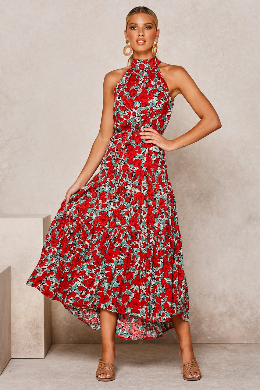 Frau in rotem, geblümtem Maxikleid mit Neckholder, posiert vor neutralem Hintergrund. Sommermode, elegantes Design, florales Muster, Damenbekleidung.