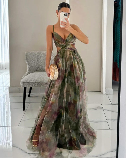 Frau im eleganten, ärmellosen Abendkleid mit Blumenmuster, hält eine runde Clutch, steht vor einem Spiegel. Perfekt für Gala oder Hochzeit.