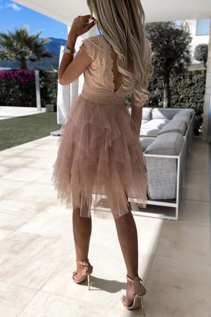 Frau in elegantem, rosa Tüllkleid mit Rüschen steht auf Terrasse; Sommermode, Abendkleid, stilvolle Kleidung, luxuriöse Umgebung.