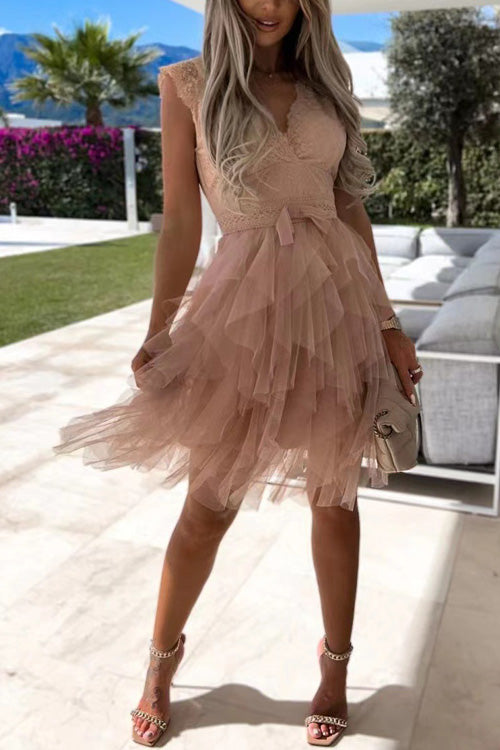 Frau in elegantem, ärmellosem, rosa Tüllkleid mit Rüschen, steht auf Terrasse. Sommermode, stilvolle Abendgarderobe, modisches Outfit.