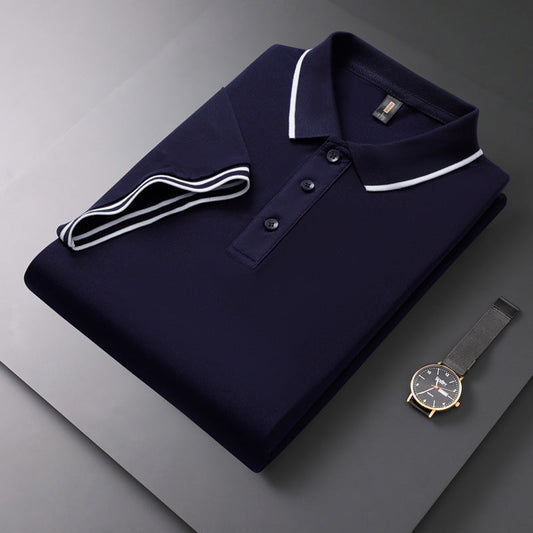 Dunkelblaues Polohemd mit weißen Streifen, gefaltet auf grauem Hintergrund, neben einer eleganten Armbanduhr. Herrenmode, stilvolles Design.