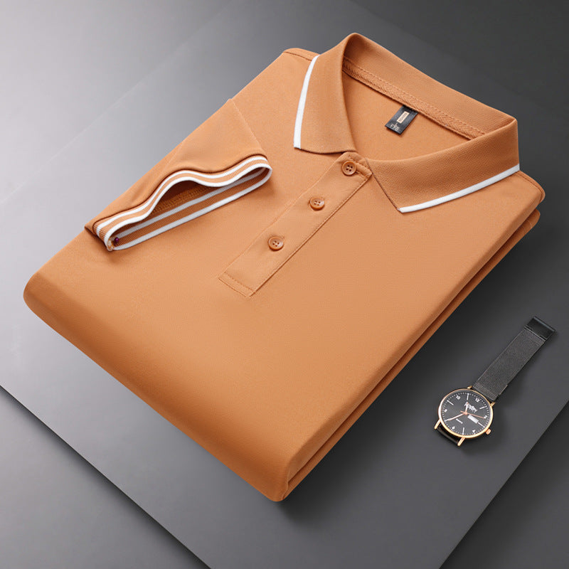 Gefaltetes orangefarbenes Polohemd mit weißem Kragen auf grauem Hintergrund, daneben eine elegante Armbanduhr. Herrenmode, stilvolles Design.