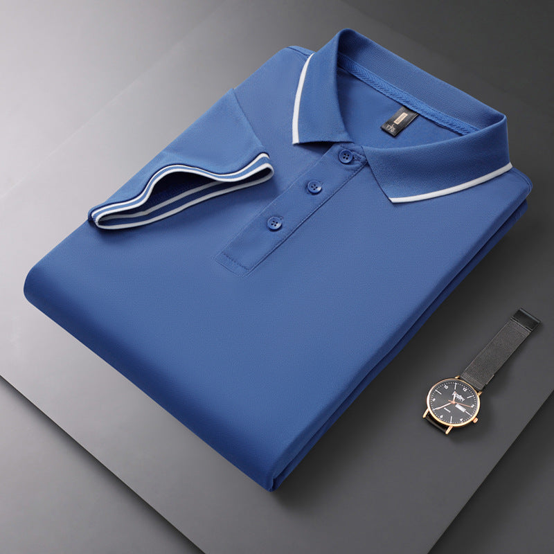 Gefaltetes blaues Polohemd mit weißen Akzenten auf grauem Hintergrund, daneben eine elegante Armbanduhr. Mode, Herrenbekleidung, Accessoires.