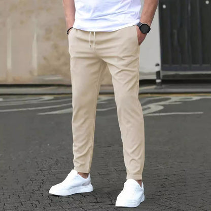 Beige Chinohose für Herren, kombiniert mit weißen Sneakers und weißem T-Shirt. Modischer Streetwear-Look, ideal für lässige Anlässe.