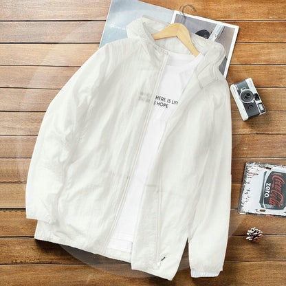 Weiße Herrenjacke mit Kapuze auf Holztisch, daneben Kamera und Coca-Cola-Deckel. Modische Freizeitkleidung, ideal für Frühling und Herbst.