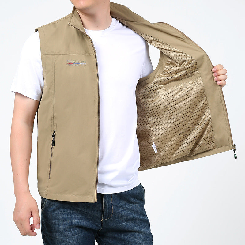 Beige Herrenweste mit Reißverschlusstaschen, getragen über weißem T-Shirt und Jeans. Ideal für Outdoor-Aktivitäten und Freizeitmode.