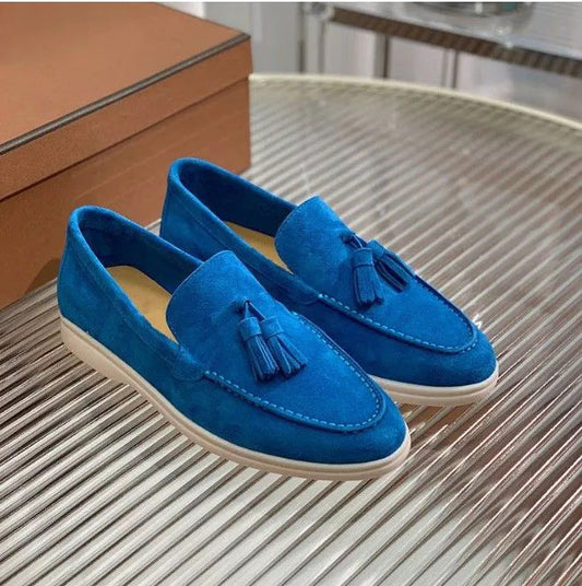 Blaue Wildleder-Loafer mit Quasten auf einem Tisch, elegantes Design, Herrenschuhe, modisch, hochwertig, stilvoll, bequem, Freizeitmode.