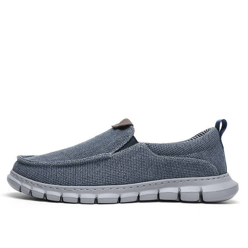 Grauer Herren-Slipper aus Stoff mit flexibler Sohle, ideal für Freizeit und Alltag. Bequemer, atmungsaktiver Schuh für Herrenmode.