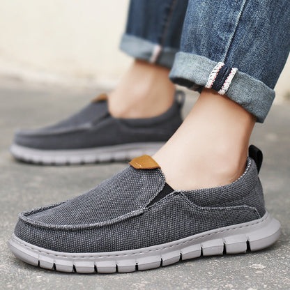 Graue Herren-Sneaker aus Stoff, kombiniert mit hochgekrempelten Jeans. Bequeme Freizeitschuhe für den Alltag. Ideal für modebewusste Männer.