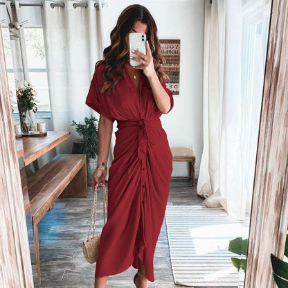 Frau in rotem Kleid macht Selfie im modernen Wohnzimmer, Holzdetails, helle Vorhänge, modische Kleidung, Innenarchitektur, Smartphone.
