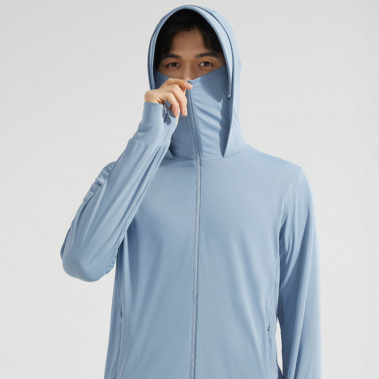 Person in hellblauer Kapuzenjacke mit hochgezogenem Reißverschluss, verdeckt Mund und Nase. Modische Sportbekleidung, atmungsaktiv, funktional.