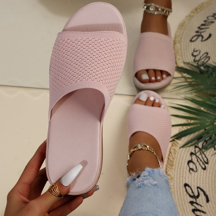 Damen rosa Strick-Slipper, modisch und bequem, getragen mit Jeans und Fußkettchen. Perfekte Sommer-Sandalen für stilvolle Freizeitoutfits.