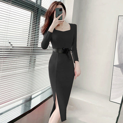 Frau in elegantem, schwarzem Kleid mit Gürtel, posiert vor Fenster. Modernes Design, lange Ärmel, seitlicher Schlitz. Mode, Damenbekleidung, Stil.