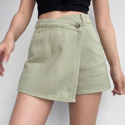 Frau trägt olivgrünen Wickelrock aus Denim, kombiniert mit schwarzem Top. Modetrend, Sommeroutfit, Damenmode, lässiger Stil.