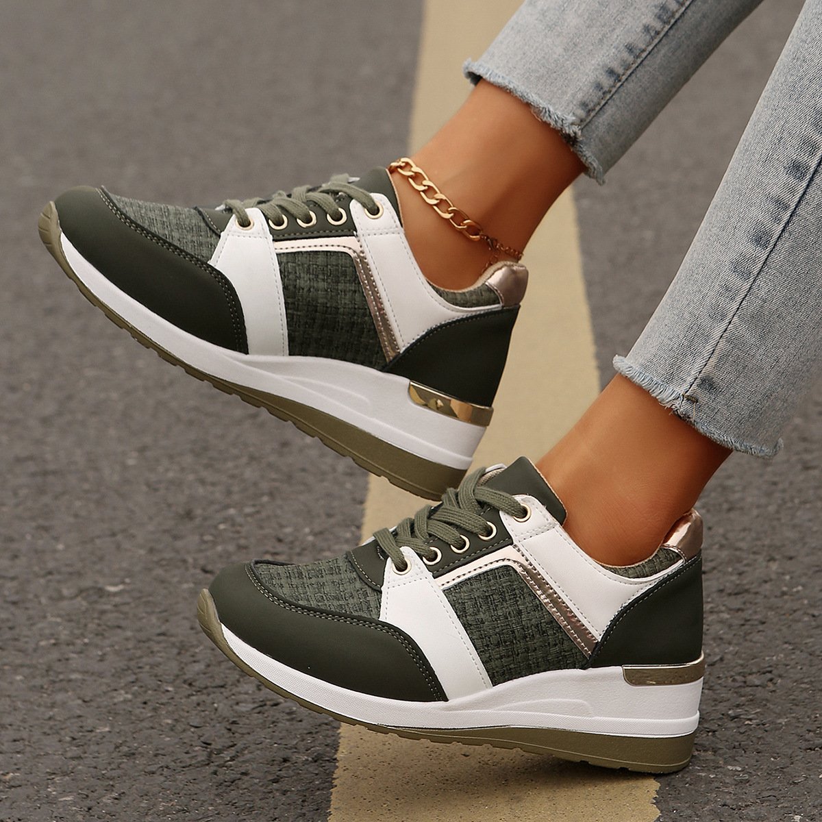 Damen Sneaker in Olivgrün und Weiß, mit goldenen Akzenten und Plateau-Sohle, getragen auf Asphalt. Modische Sportschuhe, ideal für Freizeit und Streetstyle.