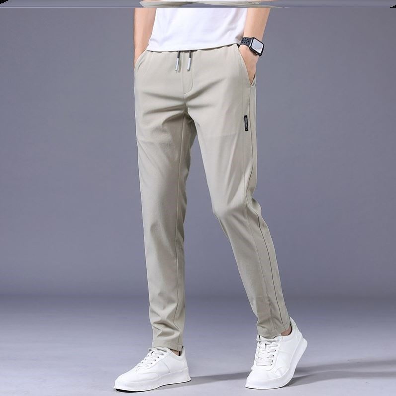Herren Jogginghose in Beige, modern und bequem, kombiniert mit weißen Sneakers. Perfekt für Freizeit und Sport. Ideal für stilvolle Herrenmode.