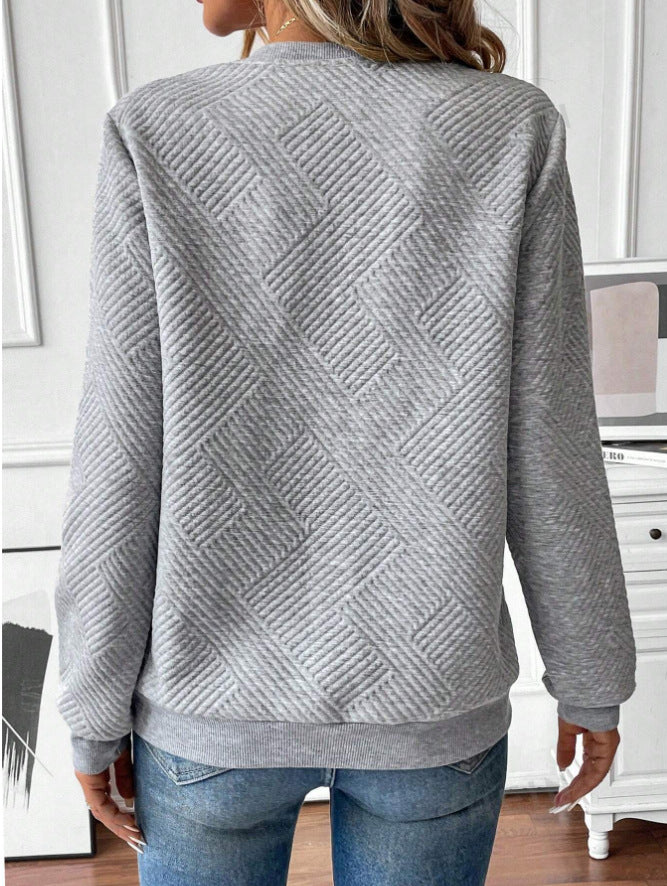 Frau in grauem, strukturiertem Pullover mit geometrischem Muster, Rückansicht. Modetrend, bequeme Freizeitkleidung, stilvoller Look.